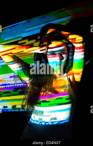 Arte digitale: una giovane donna ragazza con colorati abstract digital striped striata di image pattern proiettato sul suo viso. Foto Stock