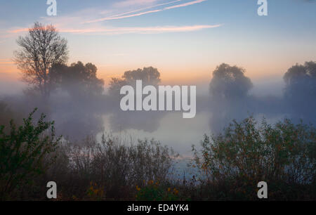 Bellissimo tramonto sul lago, foggy Foto Stock