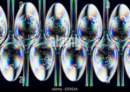 Polarizzato modelli di accentazione in fila di palette o cucchiaini di plastica con liquidi gassati dal di sopra Foto Stock