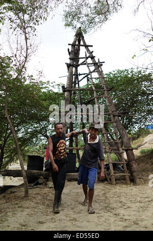 I minatori miniera di tirare per sollevare il petrolio greggio dai pozzi manualmente nel tradizionale olio mining nel sottodistretto Kedewan, Bojonegoro Foto Stock