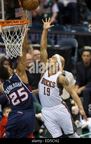 Milwaukee, WI, Stati Uniti d'America. 27 dic 2014. Milwaukee Bucks guard Jerryd Bayless (19) va per un colpo su Atlanta Hawks guard Thabo Sefolosha (25) durante il gioco NBA tra Atlanta Hawks e il Milwaukee Bucks a BMO Harris Bradley Center di Milwaukee, WI. Atlanta sconfitto Milwaukee 90-85. John Fisher/CSM/Alamy Live News Foto Stock