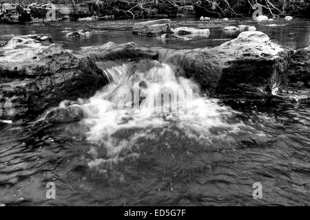 Una immagine in bianco e nero di una piccola cascata sul fiume Swale appena a valle dalla forza Wainwath in Swaledale in Yorkshir Foto Stock