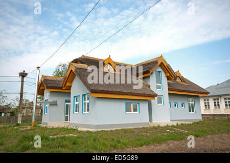 Tipico edificio nel villaggio di Caraoman e un nido di cicogna bianca (Ciconia ciconia), il delta del Danubio, Romania, Europa Foto Stock