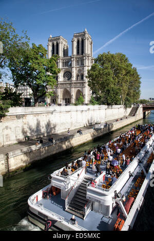 Una barca turistica sul fiume Senna passa da sotto la cattedrale di Notre Dame. Parigi, Francia. Foto Stock