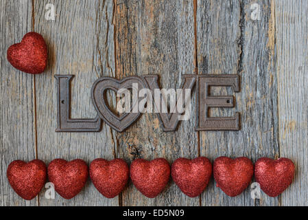 Il giorno di San Valentino cuori in legno rustico sfondo con la parola amore testo Foto Stock