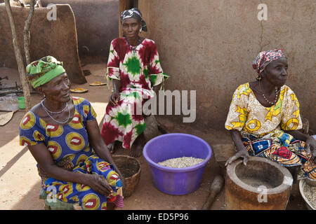 Le donne nella preparazione degli alimenti al di fuori della loro capanna di fango, Gambaga, Ghana Foto Stock