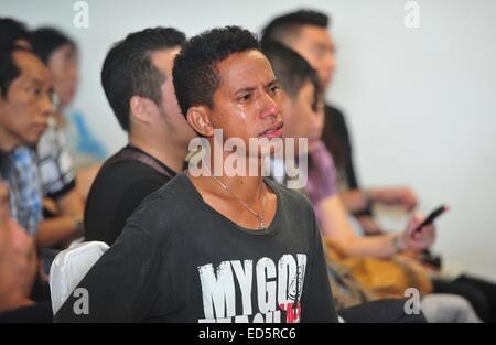 Surabaya, Indonesia. 29 dic 2014. Un uomo attende in lacrime come membri della famiglia di passeggeri sul volo AirAsia QZ8501 raccogliere all'Aeroporto Internazionale di Juanda in Surabaya, Indonesia, Dic 29, 2014. Air Asia Indonesia ha rilasciato informazioni circa i 162 passeggeri e membri di equipaggio di volo QZ8501, che ha perso il contatto con il sistema di controllo del traffico aereo la domenica mattina. Credito: Zulkarnain/Xinhua/Alamy Live News Foto Stock