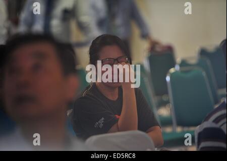 Surabaya, Indonesia. 29 dic 2014. Una donna delle salviette lacrime come membri della famiglia di passeggeri sul volo AirAsia QZ8501 raccogliere all'Aeroporto Internazionale di Juanda in Surabaya, Indonesia, Dic 29, 2014. Air Asia Indonesia ha rilasciato informazioni circa i 162 passeggeri e membri di equipaggio di volo QZ8501, che ha perso il contatto con il sistema di controllo del traffico aereo la domenica mattina. Credito: Zulkarnain/Xinhua/Alamy Live News Foto Stock