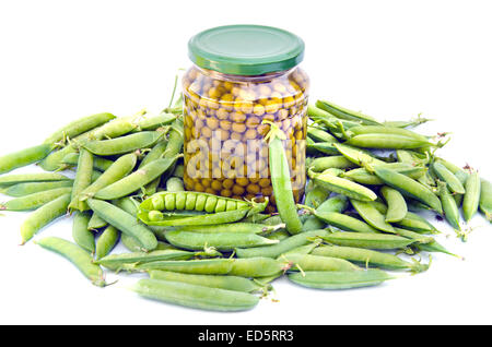 Conserve di pisello verde in un barattolo di vetro e baccelli freschi isolati su sfondo bianco Foto Stock