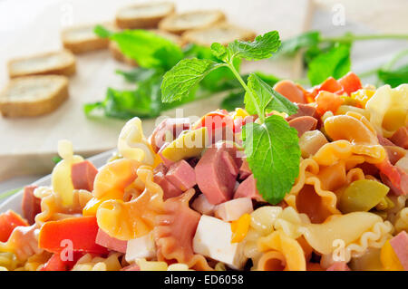 Primo piano di una rinfrescante insalata di pasta con il formaggio feta, pomodori, olive, frankfurters Foto Stock