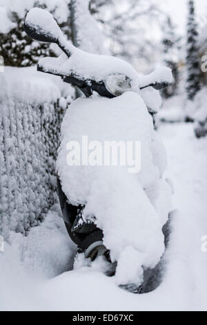 Zurigo, Svizzera. 29 dic 2014. Una coperta di neve scooter Vespa parcheggiata su una strada di Zurigo. Credito: Erik Tham/Alamy Live News Foto Stock