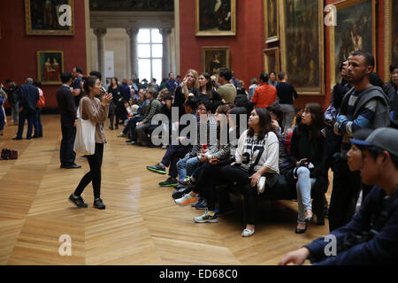 Femmina asiatica tour guida per spiegare ai turisti all'interno del museo del Louvre Foto Stock