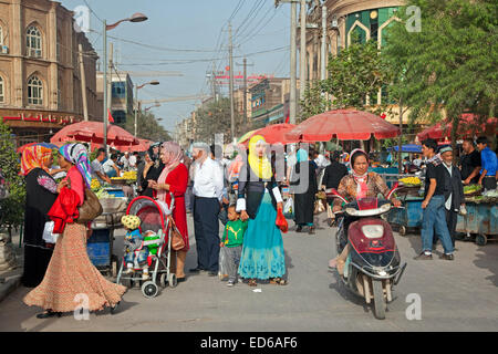 Uyghur donne Musulmane di indossare abiti islamici in strada per lo shopping in città Kashgar / Kashi, provincia dello Xinjiang, Cina Foto Stock