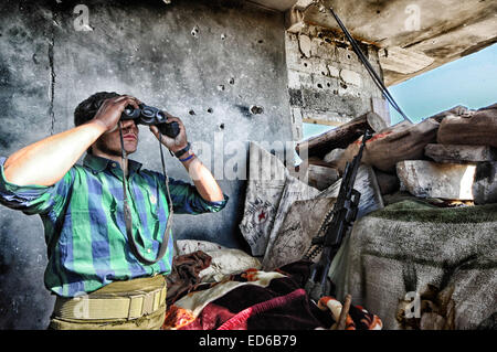 Kobane, Siria. Xxi Dec, 2014. In Kobane curdi ordinario, comprese le donne e i lavoratori anziani, sono rapidamente convertiti in condito dei veterani di guerra nelle strade e le rovine di quello che loro chiamano " il nostro Stalingrad''. Il combattimento è misurata in piedi; gli obiettivi sono edifici o anche camere in edifici. Gli edifici che sono ancora in piedi sono convertiti in rocche. Entrambi i lati sono bloccati in una lotta per la morte. I Curdi con ci torna contro la Turchia e di fronte a un nemico che nega loro la loro umanità, si è ritirata. © Gail Orenstein/ZUMA filo/Alamy Live News Foto Stock