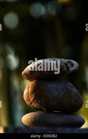 Di età compresa tra i sassi di fiume equilibrata in uno zen come il giardino giapponese. Foto Stock