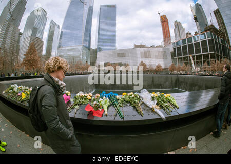 I visitatori del National September 11 Memorial & Museum di New York il Natale, giovedì, 25 dicembre 2014. Il memoriale consiste di twin pool memoriale sulle orme del World Trade Center e a plaza piantati con più di 400 Palude Bianca alberi di quercia. I nomi del 2983 vittime di 9/11 e il febbraio 1993 WTC attacco sono inscritte intorno alla base del pool. (© Richard B. Levine) Foto Stock