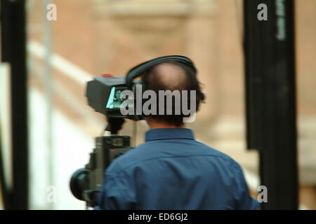 Il cameraman TV operando una telecamera broadcast Foto Stock