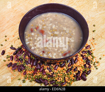 Piatto di lenticchie in un recipiente e fagioli blend sul piatto di legno Foto Stock