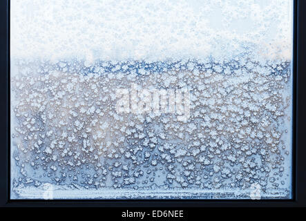 I fiocchi di neve e di gelo pattern sul vetro di finestra congelati in inverno freddo giorno Foto Stock