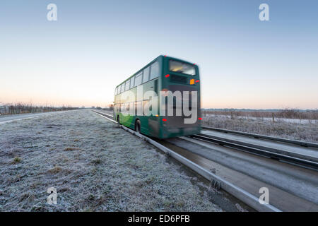 Longstanton vicino a Cambridge, UK. Il 30 dicembre, 2014. Regno Unito meteo. Un autobus guidata accompagna i " commuters " da e per Cambridge su un congelamento ma croccante mattina all'alba. La temperatura è scesa a meno 1 gradi centigradi per tutta la notte con un cielo terso portando una bella croccante all'alba. Il bus guidato è la più lunga al mondo nel suo genere e corre tra St Ives Cambridge e. Credito Eales Julian/Alamy Live News Foto Stock