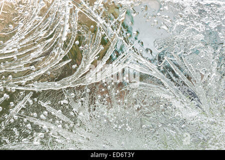 Congelate le bolle di gas aria e linee di stress acqua gelida patterns in ghiaccio con linee radianti e sentieri sul freddo pungente giornata invernale Foto Stock