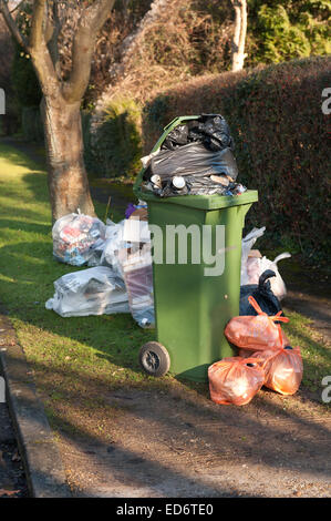 Accumulo di rifiuti domestici rifugio causando il blocco e la pila dei rifiuti e impedendo l'accesso per disabili sul marciapiede del consiglio Foto Stock