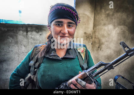 Kobane, Siria. Xxi Dec, 2014. I combattenti in Kobane uomo posizioni di pistola a sostegno di far avanzare le truppe di terra nella battaglia per Kobane contro lo Stato islamico. Le forze curde sono completamente integrato di genere. La femmina fighters mostrano una grande umiltà ed efficacia come membri nella lotta per la sopravvivenza del loro paese. © Gail Orenstein/ZUMA filo/Alamy Live News Foto Stock