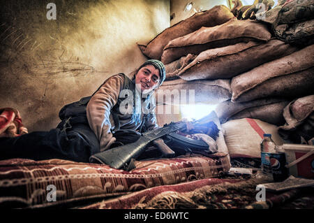 Kobane, Siria. Xxi Dec, 2014. I combattenti in Kobane uomo posizioni di pistola a sostegno di far avanzare le truppe di terra nella battaglia per Kobane contro lo Stato islamico. Le forze curde sono completamente integrato di genere. La femmina fighters mostrano una grande umiltà ed efficacia come membri nella lotta per la sopravvivenza del loro paese. © Gail Orenstein/ZUMA filo/Alamy Live News Foto Stock