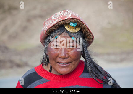 Ritratto di Khampa tibetani donna che indossa tradizionale capelli color ambra pezzo a Zhuqing, nella provincia di Sichuan, in Cina Foto Stock