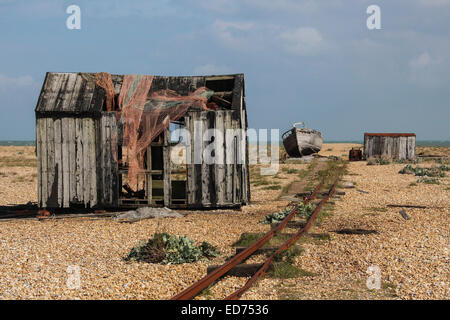 Capannoni abbandonati e sulla ghiaia a Dungeness, la Gran Bretagna è solo il deserto. Con le tracce per una piccola vecchia ferrovia. Foto Stock