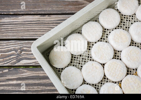 Insieme di piccoli capi di formaggio di capra crottin giacente su tavole di legno Foto Stock