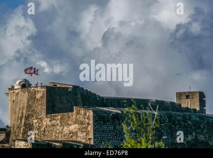 San Juan, Puerto Rico, noi. 12 gen 2009. Le bandiere degli Stati Uniti, Porto Rico, e l'impero spagnolo (le frastagliate croce rossa, un esercito spagnolo bandiera utilizzata dal XVI al XVIII secolo), sorvolare il Castillo de San Cristobal, 1783 Spagnolo costruito fort, ora parte del Sito Storico Nazionale di San Juan, che sta di guardia alla porta orientale, la terra ingresso, per le mura della città vecchia San Juan. © Arnold Drapkin/ZUMA filo/Alamy Live News Foto Stock