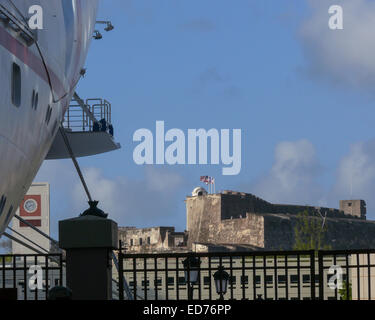 San Juan, Puerto Rico, noi. 12 gen 2009. Le bandiere degli Stati Uniti, Porto Rico, e l'impero spagnolo (le frastagliate croce rossa, un esercito spagnolo bandiera utilizzata dal XVI al XVIII secolo), sorvolare il Castillo de San Cristobal, 1783 Spagnolo costruito fort, ora parte del Sito Storico Nazionale di San Juan, che sta di guardia alla porta orientale, la terra ingresso, per le mura della città vecchia San Juan. In primo piano è una nave da crociera ormeggiata al porto. © Arnold Drapkin/ZUMA filo/Alamy Live News Foto Stock