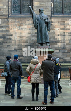 I turisti nel cortile dell Assemblea Generale della Chiesa di Scozia ammirando la statua di John Knox (c. 1514-72). Foto Stock