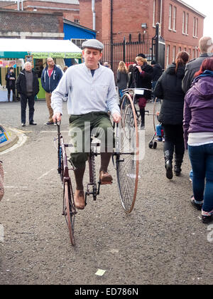 Un uomo che cavalca un Starley Bros Royal Salvo il triciclo al Victorian festa di Natale a Portsmouth Historic Dockyard Foto Stock