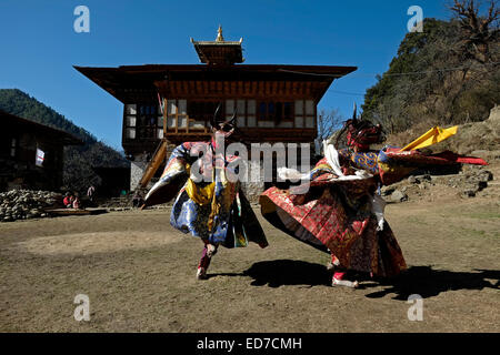 Danzatori mascherati prendendo parte a una rara e antica danza sacra chiamato Zhey non eseguita altrove in Bhutan durante il religioso annuale Tshechu bhutanesi festival in Ngang Lhakhang un monastero buddista noto anche come "wan" tempio costruito nel XVI secolo da un lama tibetano denominato Namkha Samdrip nella valle di Choekhor di Bumthang distretto centrale di Bhutan Foto Stock