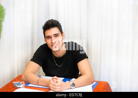 Sorridente giovane di lavorare o studiare a casa Foto Stock