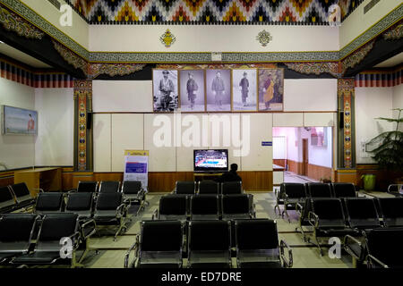 Un solo passeggero attende il suo volo all'interno della sala partenze all'aeroporto internazionale di Paro uno dei soli quattro aeroporti del Bhutan Foto Stock