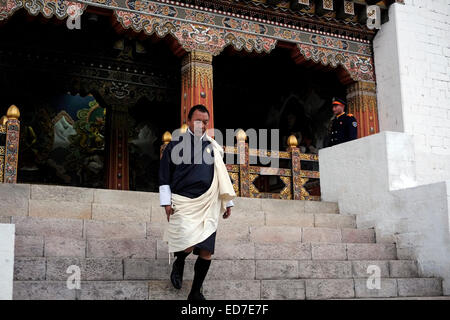 Un membro dei segretari del re esce dal Uffici governativi nella fortezza di Tashichho Dzong, sede del governo del Bhutan dal 1952 e attualmente ospita la sala del trono e gli uffici del re ai margini della città di Thimphu la capitale del Bhutan Foto Stock