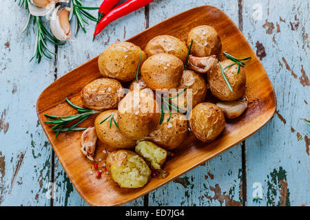 Patate al forno intero nella loro pelli con rosmarino e aglio Foto Stock