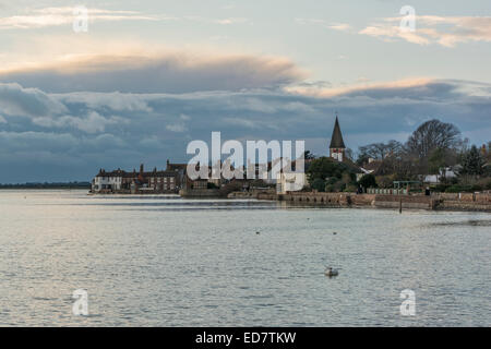 Bosham canale a bassa marea con il villaggio in background, Bosham, West Sussex, in Inghilterra, Regno Unito. Foto Stock