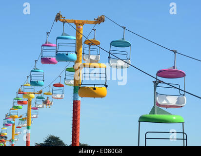 Sedili colorati dal parco dei divertimenti di corsa contro il cielo blu Foto Stock