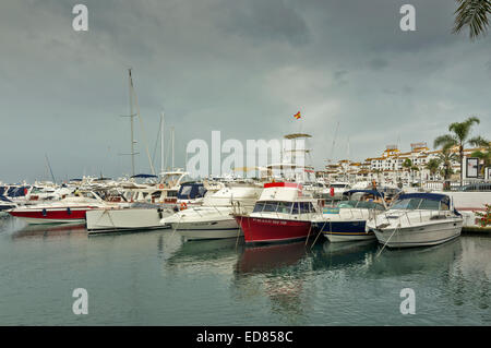 Piccole imbarcazioni e charter di pesca in porto turistico di Puerto Banus Costa del sol Spagna in un giorno di pioggia Foto Stock
