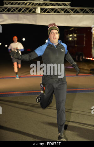 Prato est, New York, Stati Uniti d'America. 1a gen, 2015. Un runner attraversa la linea del traguardo in 5K Capodanno DASH per sostenere il Long Island Consiglio sull Alcolismo e Tossicodipendenza (LICADD) presso Twin le piste di pattinaggio sul ghiaccio al centro di Eisenhower Park di Long Island. Un' Skatin Capodanno evento iniziato ore precedenti e una festa di Capodanno, aperto a corridori, la famiglia e gli amici hanno continuato fino alle 2:30 a.m. © Ann Parry/ZUMA filo/Alamy Live News Foto Stock