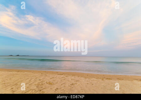 Una lunga esposizione shot al tramonto da un tropicale spiaggia deserta durante il monsone di tempo. Sfocato effetto mare, colori pastello. Foto Stock