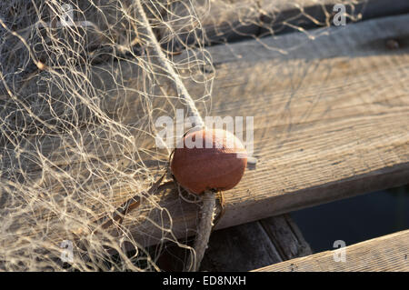 Rete da pesca con galleggianti in appoggio sul pontile in legno Foto Stock