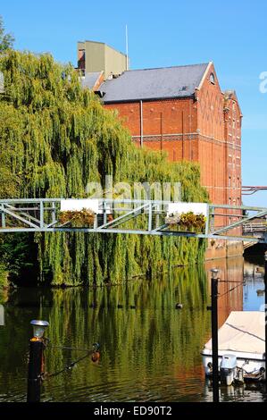 Vista di guarigioni Mill lungo il fiume Avon con un ponte pedonale in primo piano, Tewkesbury, Gloucestershire, England, Regno Unito, Wester Foto Stock