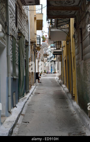 Scena di strada nel villaggio di Pyrgi, Chios, con una vecchia donna su un sedile Foto Stock