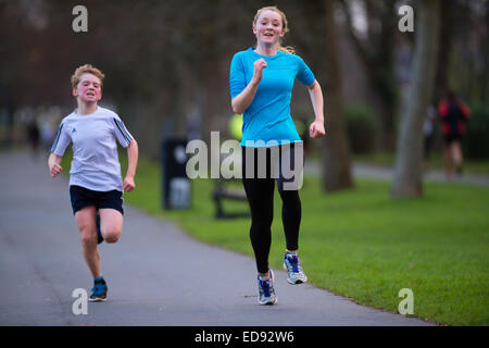 I gemelli rivalità: due giovani corridori - fratello e sorella - un ragazzo e una ragazza - prendendo parte alla Aberystwyth 5K Park Run, Plascrug Avenue, su un Sabato mattina di dicembre. Foto Stock