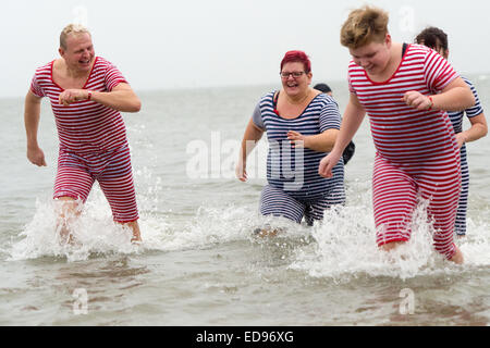 Foehr, Germania. 1a gen, 2015. Vestiti in maniera colorata persone tuffarsi nel mare del Nord a Wyk su Foehr, Germania, 1 gennaio 2015. Oltre 300 persone saltato in mare sull'isola di Foehr. Centinaia di intrepidi nuotatori soddisfare fino a Capodanno in luoghi diversi in Schleswig-Holstein. Per iniziare il nuovo anno saltando in acqua ghiacciata si sta lentamente guadagnando il carattere di culto. Foto: MAURIZIO GAMBARINI/dpa/Alamy Live News Foto Stock